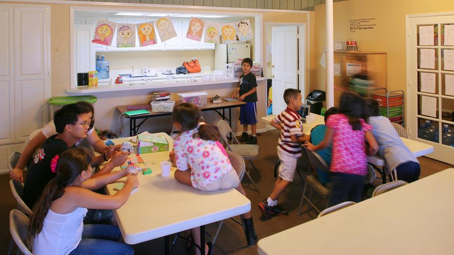 a group of children sitting around a table.