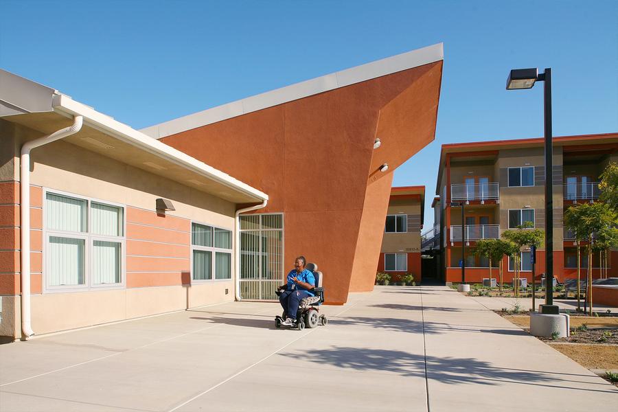 a man riding a scooter in front of a building.