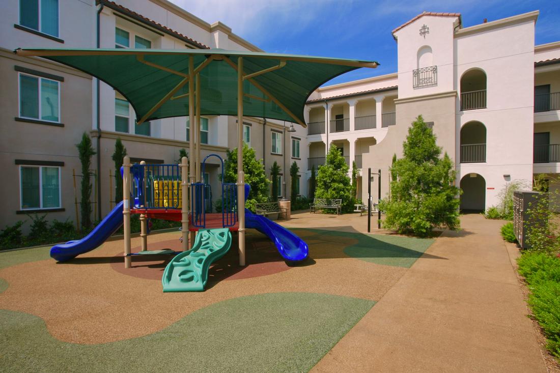 a children's play area in front of a multi - story building.