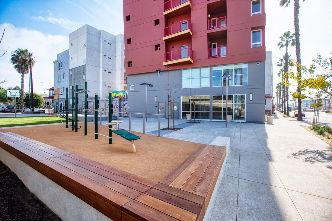 a playground in front of a multi - story building.