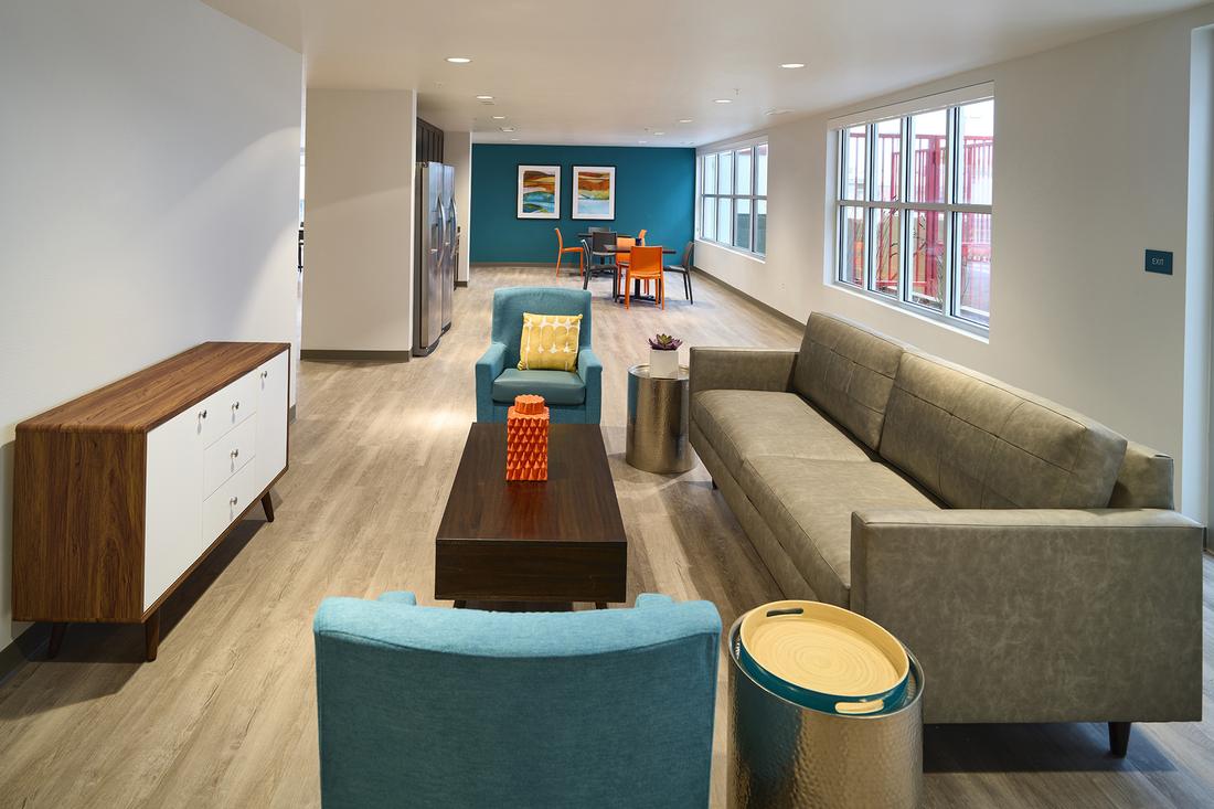 a living room filled with furniture and lots of windows.