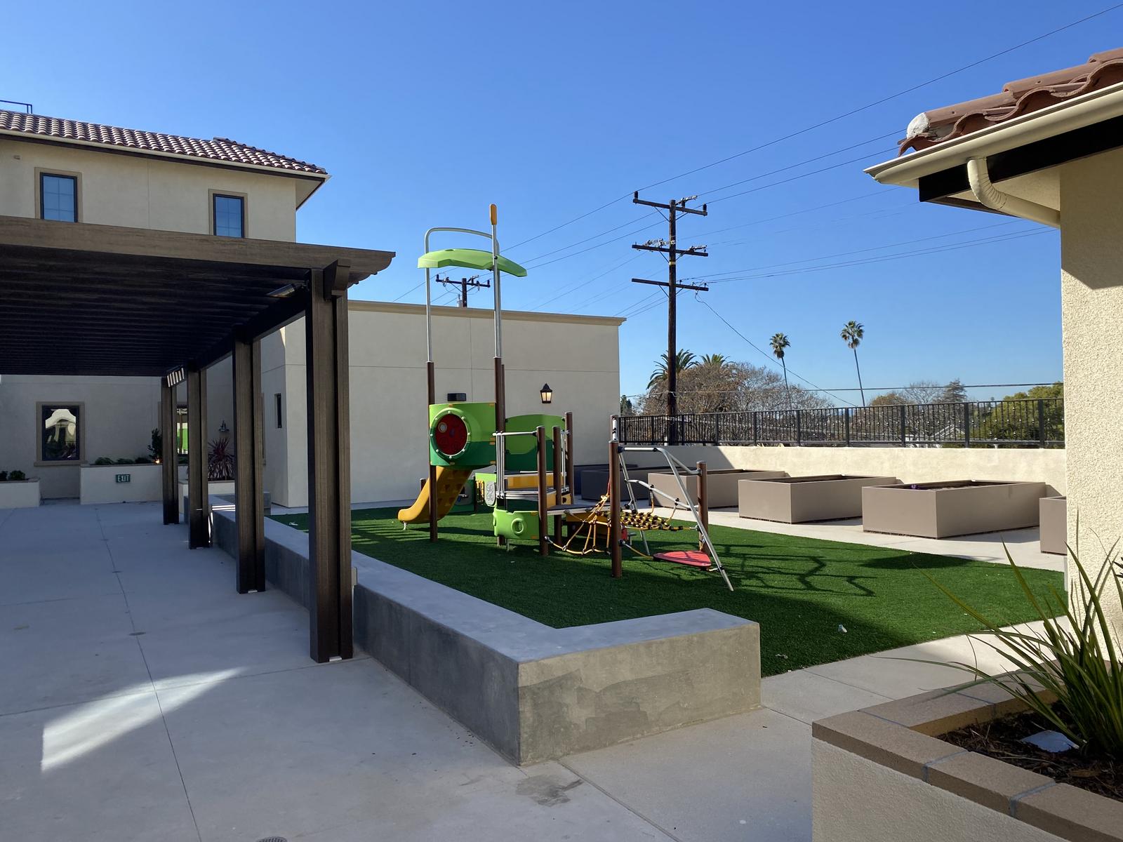 a play area with artificial grass and a slide.