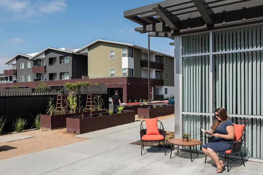 a woman sitting in a chair on a patio.