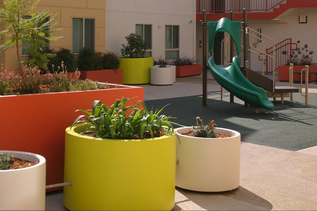 a children's play area with a slide and potted plants.