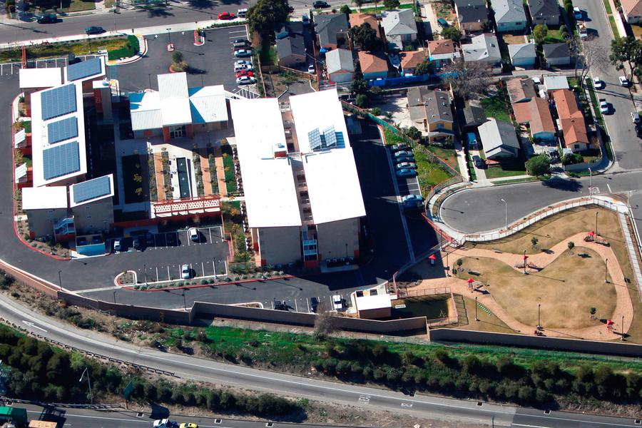 an aerial view of a building with a lot of cars parked in front of it.