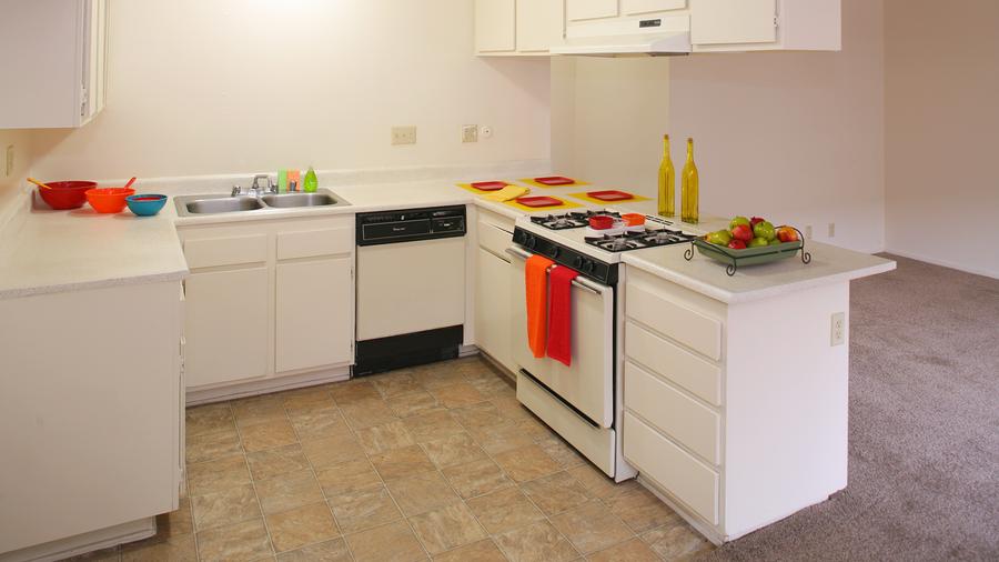 a kitchen with a stove top oven next to a sink.
