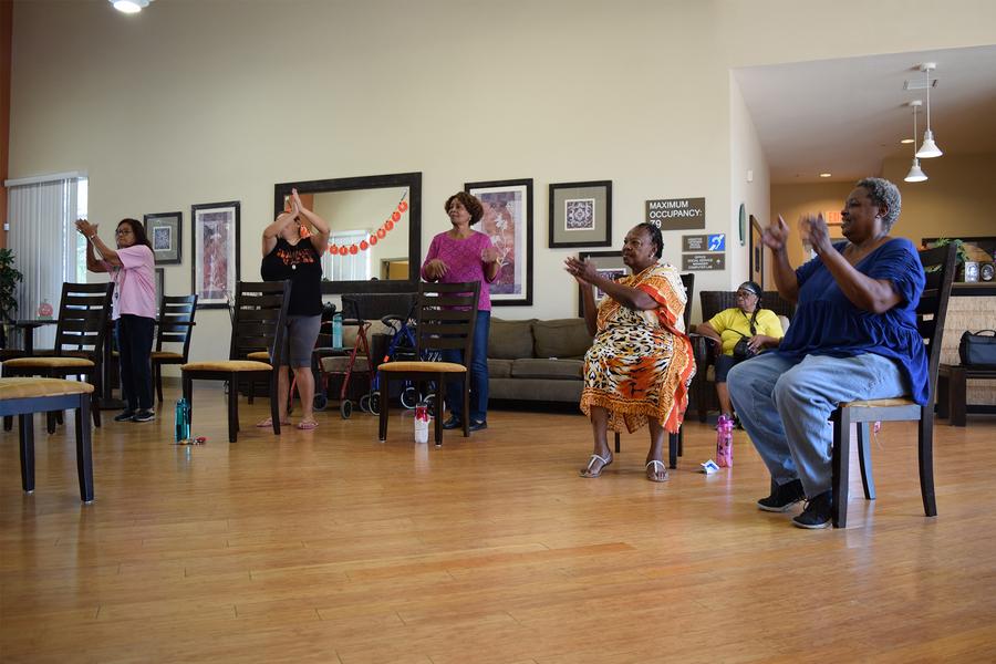 a group of people standing in a living room.